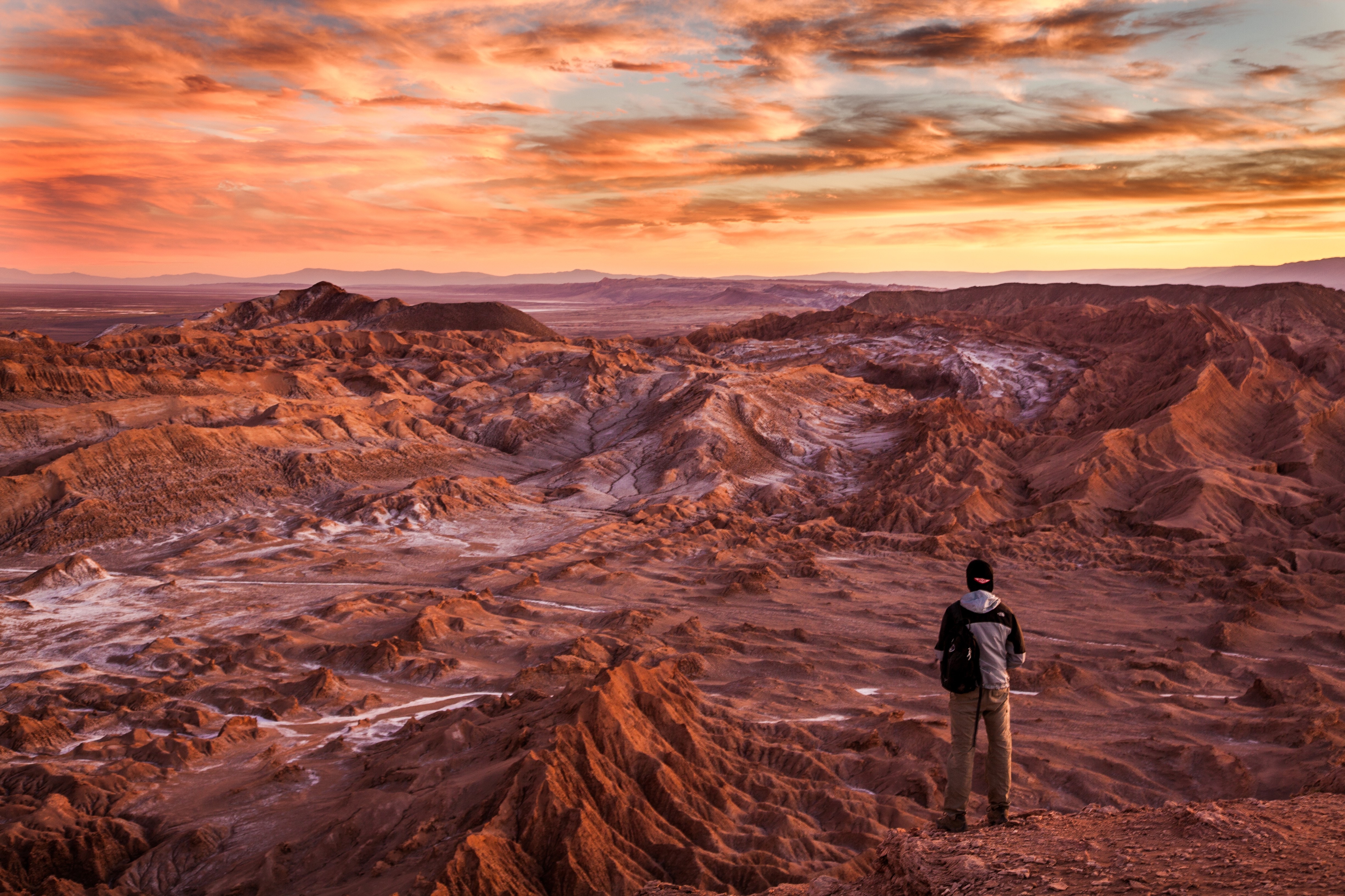 Guy watching a rough terrain while the sun sets